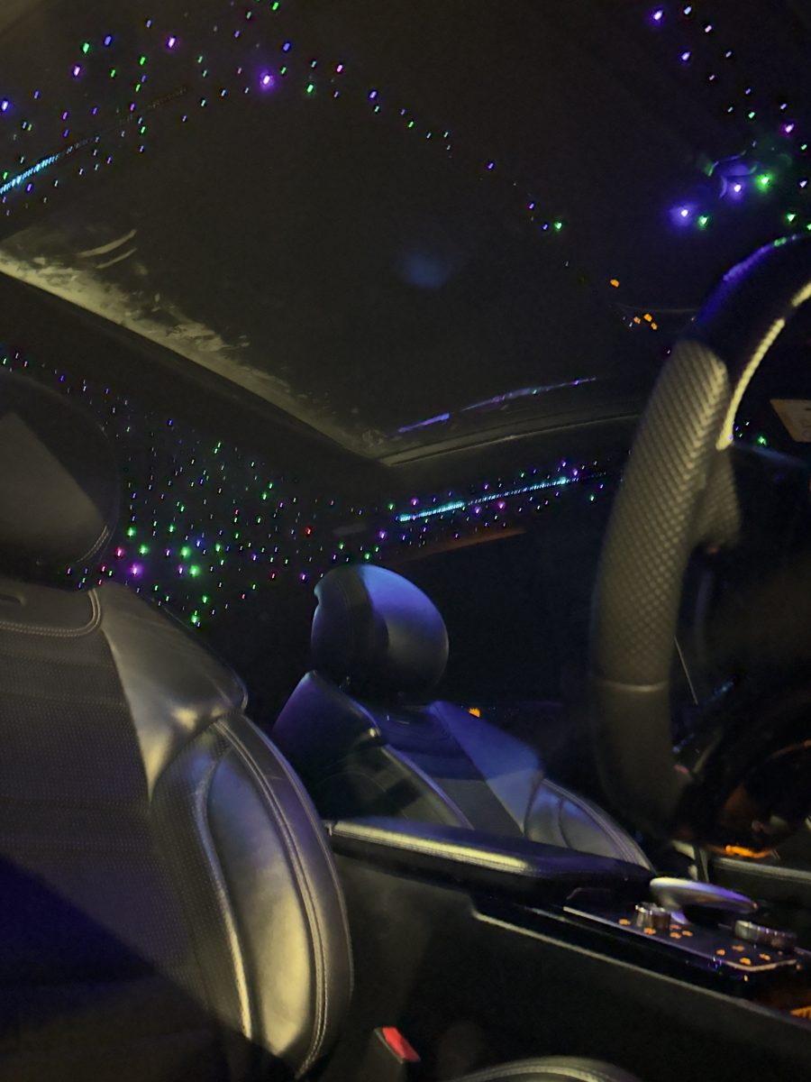 Fibre-optic starlight headliner glowing purple and green at night